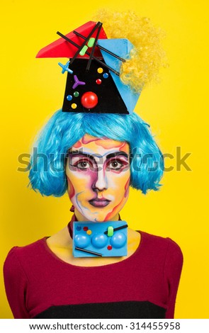 Studio art photo girls c blue hair and art makeup and positive emotions on a yellow background