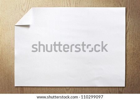 page of White paper folded on wood background with shadow