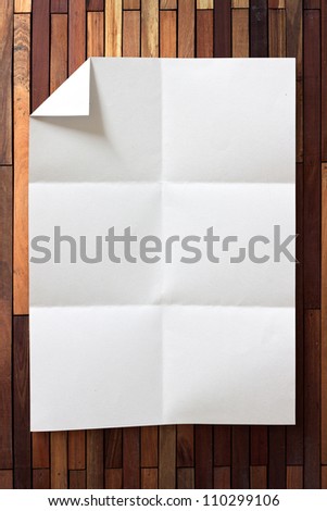 page of White paper folded and wrinkled on wood background with shadow