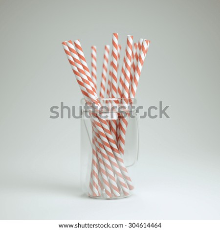 Drinking straws in a jar over white background