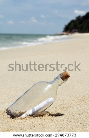 Message in a bottle on sandy white beach