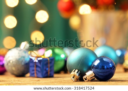 Christmas ornaments on wooden surface with blurred background of lights