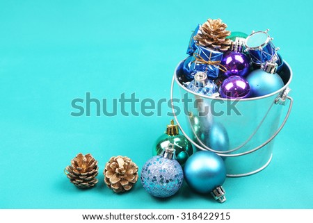 Blue Christmas tree ornaments in steel bucket on blue background