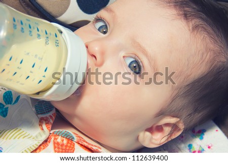 child eating out of a plastic bottle