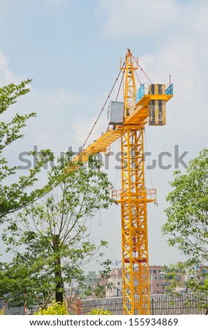 Yellow construction crane isolated on clear blue sky.