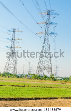 tower for electricity in rural landscape under blue sky