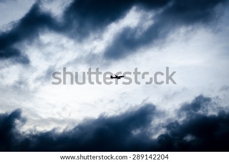 The airplane fly in to gray clouds just before storm