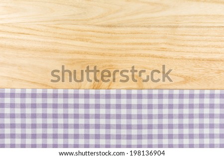 Purple checkered table cloth on a wooden background