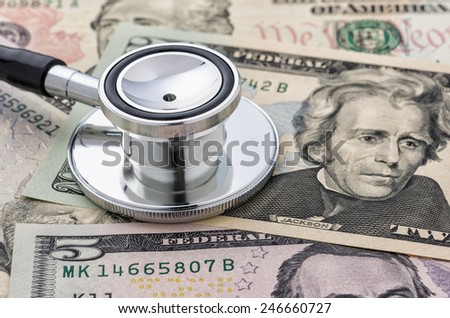 Close-up of a stethoscope on dollar bills