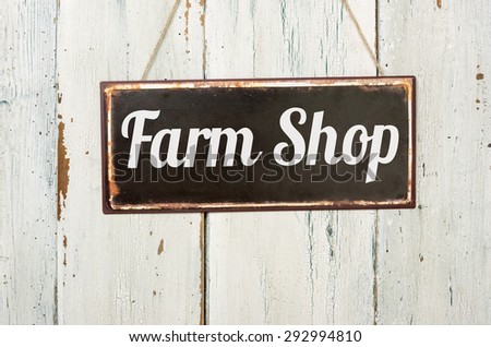 Old metal sign in front of a white wooden wall - Farm Shop