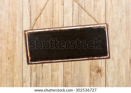 Empty metal sign on a wooden wall