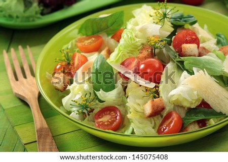 Caesar salad / mixed green salad with  Lettuce, Spinach, Parmesan cheese, croutons  and fresh Cherry Tomatoes  in a  bowl