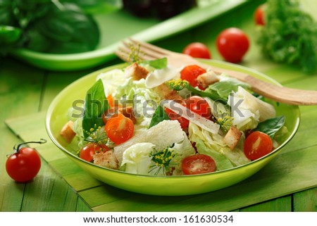 Mixed green salad with  Lettuce, Spinach, Parmesan cheese, croutons  and fresh Cherry Tomatoes  in a  bowl
