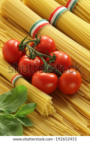 Italian cuisine: Spaghetti bunches, cherry tomatoes and basil l still life
