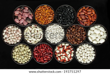 Assortment beans in round bowls on black background
