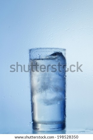 Water glass with ice cubes isolated on white background
