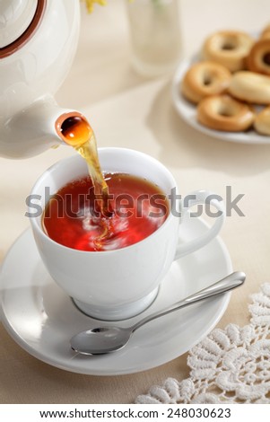 Pouring tea from teapot to the tea cup