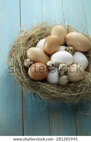 Fresh hen\'s eggs from the farm in the basket / nest on wooden background