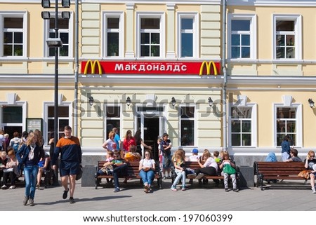 MOSCOW - MAY 31: People resting on benches near McDonald\'s restaurant building on Tolmachesvsky street on May 31, 2014 in Moscow.
