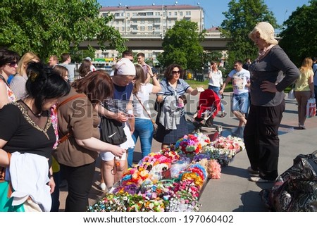 MOSCOW - MAY 31: Women buying artificial flowers wreaths on Cosmonauts Alley on May 31, 2014 in Moscow.