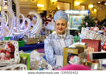 MOSCOW - DECEMBER 21: The seller dressed in festive clothes selling Christmas decorations in the GUM store on December 21, 2014 in Moscow.