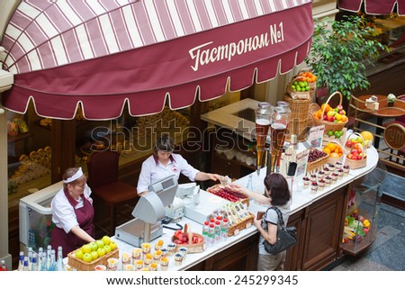 MOSCOW - JULY 29: The seller of fruits, juices and soft drinks taking the money from the buyer to the GUM store on July 29, 2014 in Moscow.