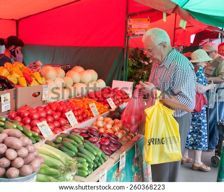 MOSCOW - AUGUST 08: Senior man buying vegetables in Vegetable Fair on Leskov Street on August 8, 2014 in Moscow.