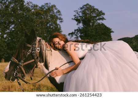 Beautiful and stunning bride, riding a horse in the nature, on her wedding day