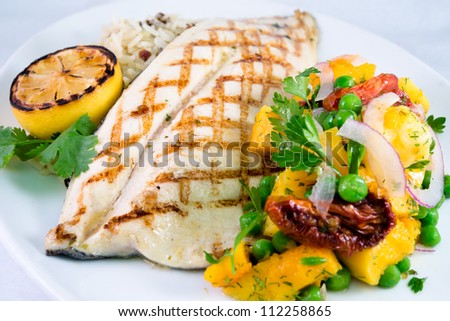 Grilled Trout and Butternut Squash: Gourmet barbecued grilled trout with grill marks and a side vegetable salsa and rice on a white plate.
