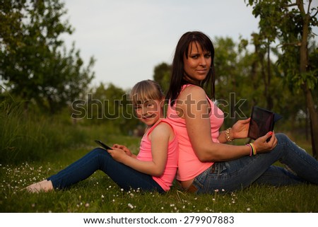 Mother and daughter working on a tablet.
