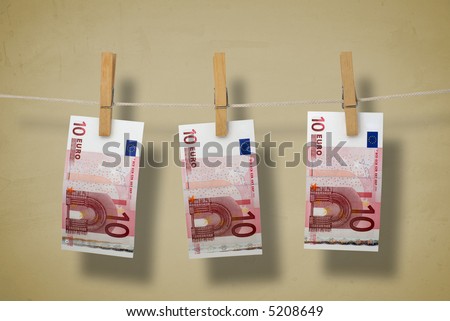 Paper money on a clothesline. Symbolizing money laundering. On texture bright brown background.
