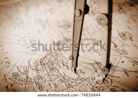 Concept shot of a old map with navigation circle. Note the shallow depth of field and hard light.