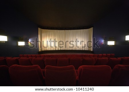 Rows of chairs in a cinema with the curtain drawn
