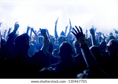 cheering crowd in front of bright blue stage lights