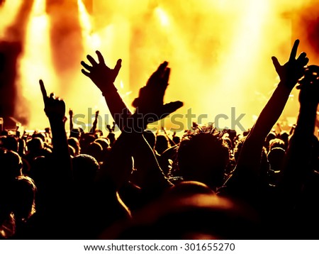 silhouettes of concert crowd in front of bright stage lights - a small DOF signifies that the focused area is narrow
