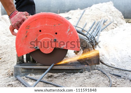 builder worker cutting steel rod by machine on a day at the construction site