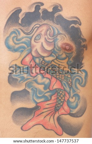 close up shot of carp, koi fish tattoo on chest - belly of a man