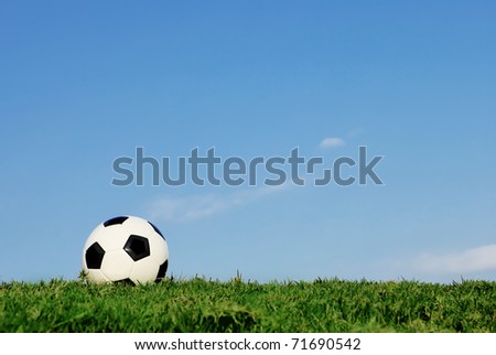 lone football on green football pitch of healthy strong grass