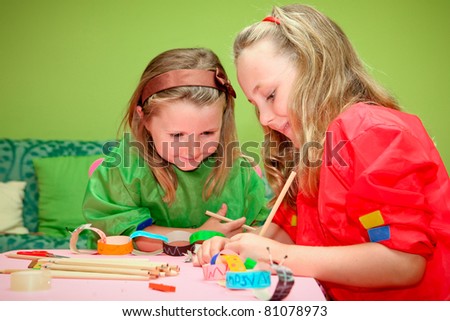 happy smiling children playing drawing and making craft in class at kindergarden school