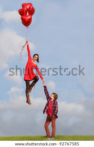 valentines teen couple flying on heart air balloons
