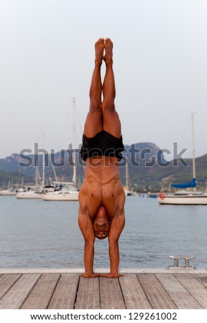 fit healthy strong man doing balance hand stand