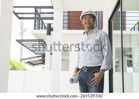 Portrait of  Asian male contractor engineer with hard hat holdin