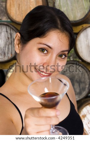 Beautiful woman with wine and barrels in the background.