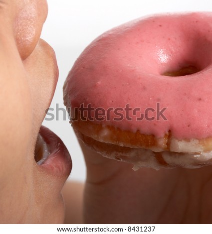 taking a bite out of a doughnut over a white background