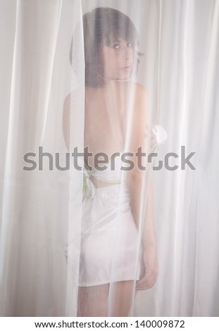 Woman Behind White Sheer Curtain
