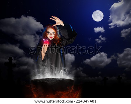 Young witch with red potion and cauldron  at night sky background