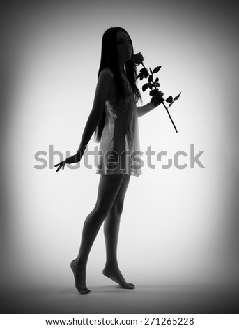 Silhouette of young girl with rose flower on gray background (black and white)