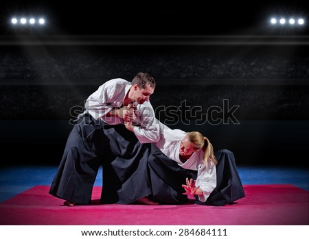 Fight between two martial arts fighters at sports hall