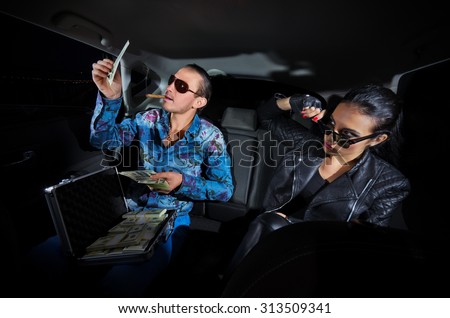 Two gangsters with dollars in the car