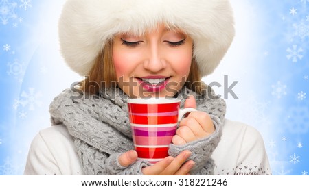 Young girl with mug on blue snowy background